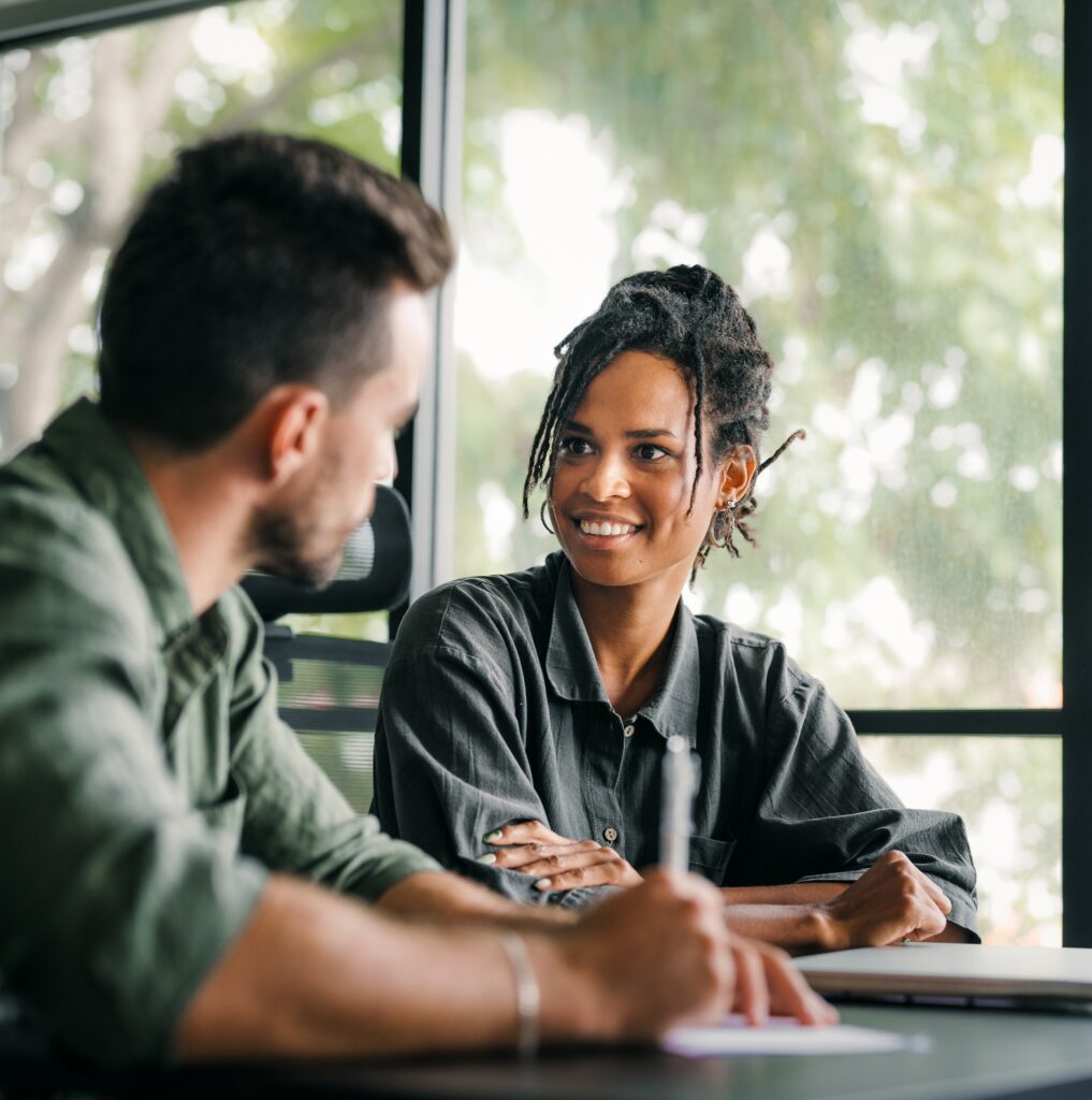 Happy business team, talking in corporate office using laptop computer.